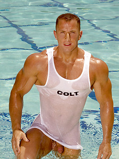 Muscle man posing by the pool