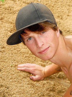 Nude skinny boy playing in the sand