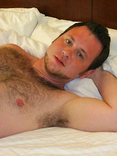  Young furry stud Sean Harte rolls around on the bed showing off his hairy ass and thick hard cock
